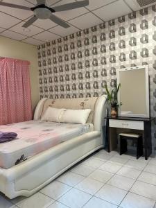 a bedroom with a bed and a table with a mirror at Taman Gerik Homestay in Gerik
