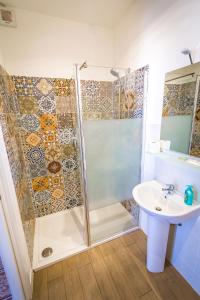 a bathroom with a shower, sink, and toilet at Liberty Suites in Palermo