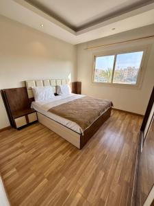 a bedroom with a large bed and a window at charming cozy retreat in the address compound in Sheikh Zayed +14 photos