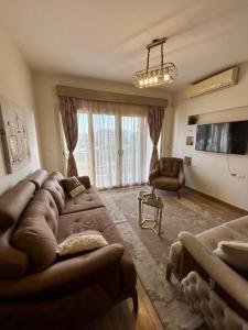 a large living room with a large couch and chairs at charming cozy retreat in the address compound in Sheikh Zayed