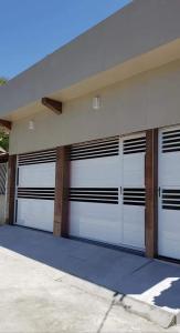 ein Gebäude mit vier weißen Garagentoren in der Unterkunft Aconchego do São Francisco in Canindé de São Francisco