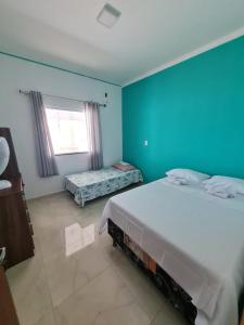 ein Schlafzimmer mit einem großen Bett und einer blauen Wand in der Unterkunft Aconchego do São Francisco in Canindé de São Francisco