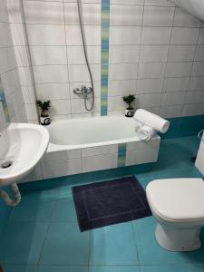 ein Badezimmer mit Badewanne, Toilette und Waschbecken in der Unterkunft Arachova Comfort in Arachova