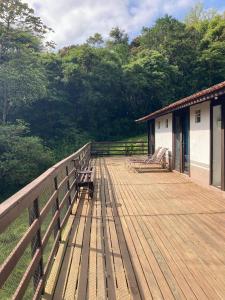 una terraza de madera con bancos en la parte superior de una casa en Casa Reserva Encantada, en Garopaba 13 fotos más