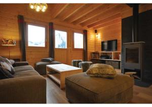 un salon avec un canapé et une télévision dans l'établissement Grand Chalet au Praz de Lys, à Taninges