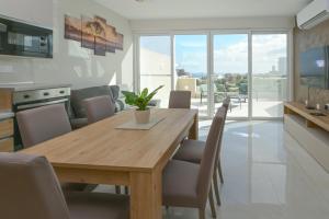 una cucina e una sala da pranzo con tavolo e sedie in legno di Lovely and spacious penthouse 2 bed 1 bath with wide panoramic views a Pembroke