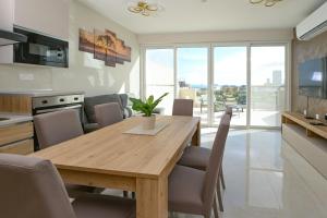 una cucina e una sala da pranzo con tavolo e sedie in legno di Lovely and spacious penthouse 2 bed 1 bath with wide panoramic views a Pembroke