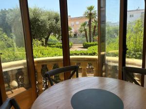 une table et des chaises devant une grande fenêtre dans l'établissement Relax by the Sea Cosy Apartment Javea Port, à Jávea