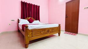 a bedroom with a wooden bed with a red curtain at 10 mins to Rock Beach-Sérénade Homestay in Puducherry +4 photos