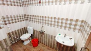 a bathroom with a toilet and a sink at 10 mins to Rock Beach-Sérénade Homestay in Puducherry
