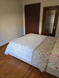 a large bed in a bedroom with a wooden floor at Quiet Room in Florina
