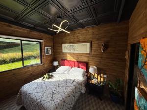 Un dormitorio con una cama y un ventilador de techo. en Mini House Reserva Natural, en Guarne 11 fotos más