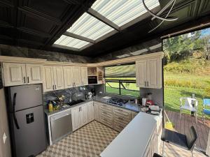 Una cocina con gabinetes blancos y una ventana grande. en Mini House Reserva Natural, en Guarne