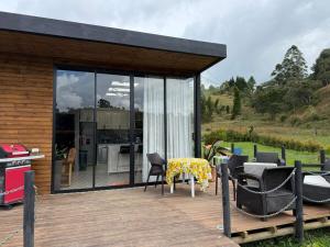 Casa con terraza con mesa y parrilla en Mini House Reserva Natural, en Guarne