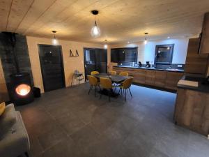 a kitchen and dining room with a table and chairs at Le Chalet de l'Ancerf in Faucompierre
