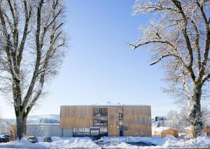 a building in the snow with two trees at Euler Neuschönau - Naturhotel & Chalets in Neuschönau