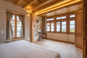 une chambre avec un lit, un bureau et des fenêtres dans l'établissement Casona Azul Llue - Asturias Vacations, à Colunga