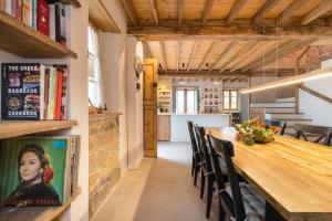 une cuisine et une salle à manger avec une grande table et des chaises en bois dans l'établissement Casona Azul Llue - Asturias Vacations, à Colunga