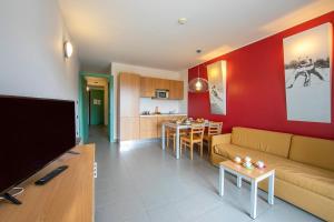 un salon avec un canapé et une cuisine dans l'établissement Villaggio Olimpico, à Sestrières