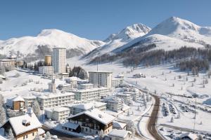 Une ville dans la neige avec des montagnes en arrière-plan dans l'établissement Villaggio Olimpico, à Sestrières 119 autres photos
