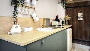 a kitchen with a counter top with a sink at L'Amaryllis, suite romantique Jacuzzi et Parking in Cintegabelle +22 photos