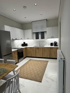 a large kitchen with white cabinets and a table and a counter at Sea & Stone House in Nafpaktos