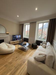 a living room with a couch and a tv at La Suite Haussman in Guéret