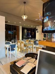 une salle à manger avec des tables, des chaises et une télévision dans l'établissement Vila Apartment with garden, à Saranda