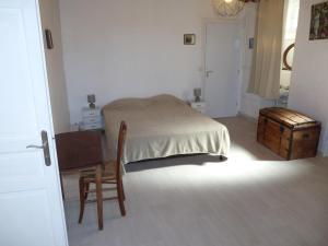 una camera da letto con un letto, una sedia e un tavolo di teranova sur le port a La Celle-sous-Gouzon