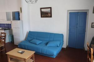un divano blu in un soggiorno con un tavolo di teranova sur le port a La Celle-sous-Gouzon