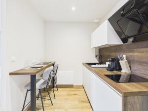 a kitchen with a counter and a table with chairs at La petite suite Ponote in Le Puy en Velay