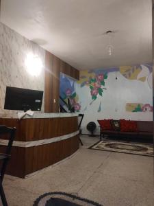 un hall d'entrée avec un mur où se trouvent une télévision et un canapé dans l'établissement Pousada Dádiva Lirío Encantado a passos da Praia do Pontal e Centro, à Parati