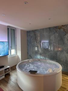 a large bath tub in a room with a tv at La petite suite Ponote in Le Puy en Velay