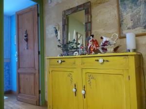 een gele kast in een kamer met een spiegel bij Chambre La Petite Pause - Bordeaux in Bordeaux