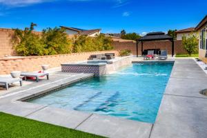 a swimming pool in a backyard with a table and chairs at #Marbella Lane - Desert Dream Pool Spa & Games in Desert Hot Springs