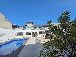 a house with a swimming pool in front of it at Pousada Brisas de Búzios in Búzios