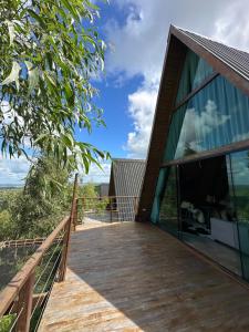 a wooden deck with glass doors on a house at Chalés Mirante da Serra PB in Serra da Raiz