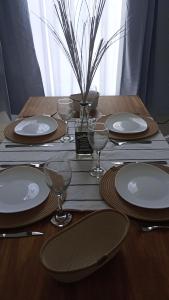 a wooden table with plates and wine glasses on it at Almablanca in San Antonio de Areco