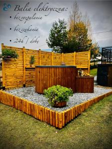 a garden with a wooden fence and two potted plants at ORAWSKA CHATA - domek z balią pod Babią Górą in Zubrzyca Górna