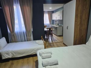 um quarto com 2 camas e uma cozinha com uma mesa em Hotel Ari em Prizren