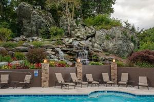 a swimming pool with chairs and a waterfall at The Tree House at Echota in Boone