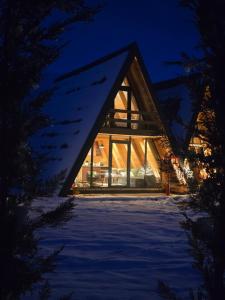 a cabin in the woods in the snow at night at White Forest Durmitor 2 in Žabljak