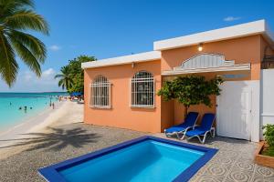 a house with a swimming pool next to the beach at Villa Privada con Piscina a Minutos del Aeropuerto de Santo Domingo in Boca Chica