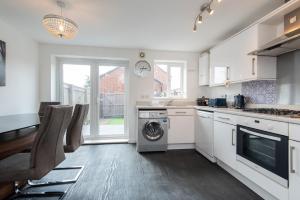 a kitchen with white cabinets and a washer and dryer at Thinford View 4 bed, 2bath, Parking, Garage in Spennymoor