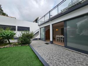 einem externen Blick auf ein Haus mit einer Terrasse in der Unterkunft Casa Trevo de 4 Folhas in Furnas