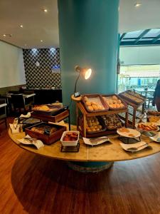 累西腓Valor Imbatível ! Flat Frente Mar com Enxoval completo的一张桌子上放着许多不同类型的糕点