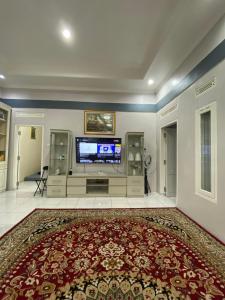 a large living room with a television and a large rug at Villa Pangalengan in Palayangan +11 photos