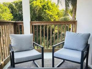 two chairs sitting on a porch with a fence at Tropical Bliss in George Town