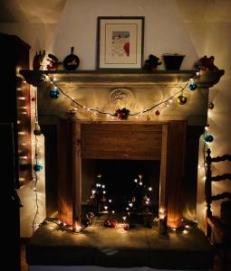 une cheminée avec des guirlandes lumineuses et des décorations de Noël dans l'établissement Antica Fiera, à Caprese Michelangelo