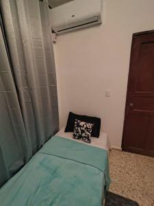 a small bed with a pillow on it in a room at La Guarida de Mela in Santo Domingo